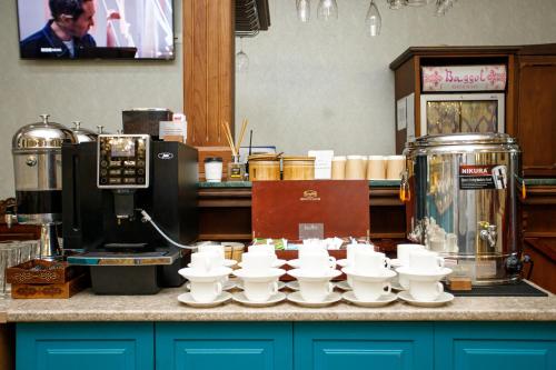 een aanrecht met witte kopjes en een koffiezetapparaat bij Ichan Qal'a Premium Class Hotel in Tasjkent