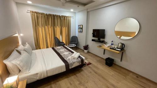 a hotel room with a bed and a mirror at Saltstayz Sector 39 - Near Medanta Hospital in Gurgaon
