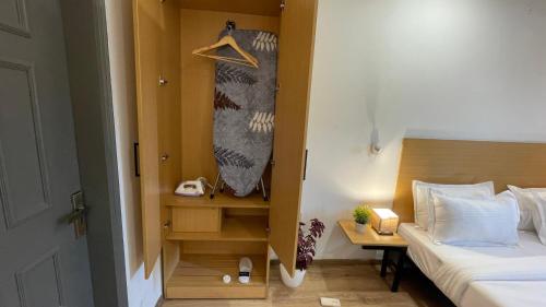 a small bedroom with a bed and a wooden cabinet at Saltstayz Express -Medicity Near Medanta Hospital in Gurgaon