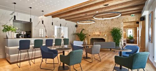 een restaurant met tafels en stoelen en een open haard bij Hotel Le Chevalier Bleu in Monpazier