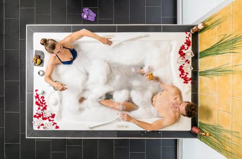 une photo d'un homme et d'une femme dans une baignoire dans l'établissement Hotel Vier Jahreszeiten am Schluchsee, à Schluchsee