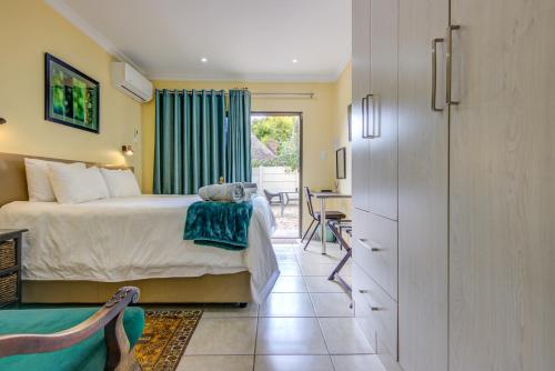 um quarto com uma cama, uma mesa e uma cadeira em Edenvale Guest House em Edenvale