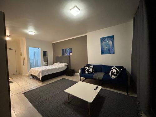 sala de estar con sofá y cama en Four Seasons Apartments, en Ciudad del Cabo