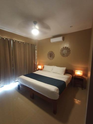 a bedroom with a large bed with two lights on it at Southseas Beach Resort and Dive Center in Santander