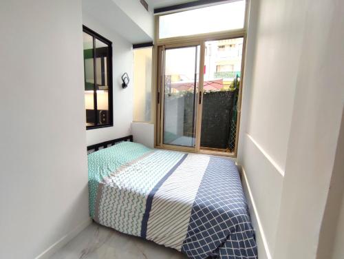 une petite chambre avec un lit et une fenêtre dans l'établissement GARDEN LEVEL nearby beach, à Nice