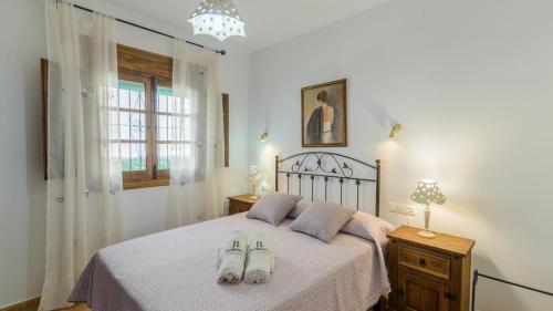 Casa Amelia Competa by Ruralidays في كومبيتا: غرفة نوم عليها سرير وحذيين