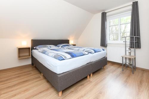 un dormitorio con una cama y una ventana en Cliner Nordseehus, en Carolinensiel