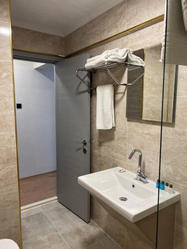 a bathroom with a sink and a mirror and a door at GRAND KENT OTEL in Bilecik