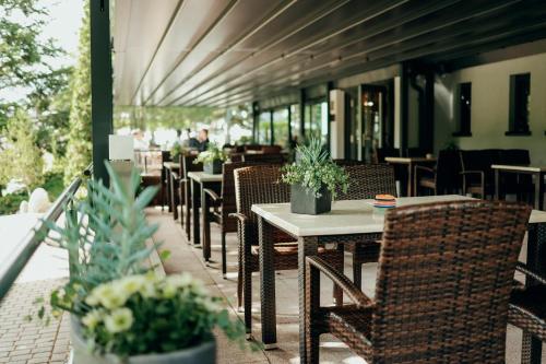 an outdoor patio with tables and chairs and potted plants at Paulshöhe in Waren
