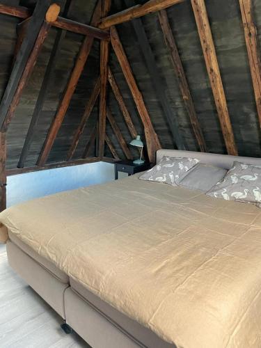a bedroom with a large bed in a attic at B&B Hoogstraat in Dokkum