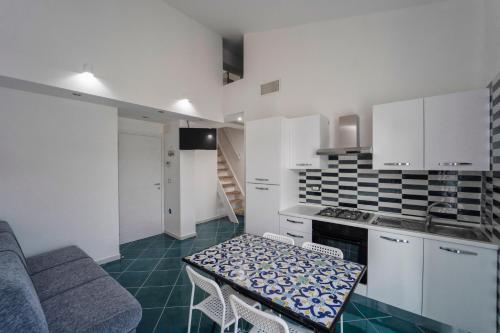 eine Küche mit weißen Schränken und einem Tisch im Zimmer in der Unterkunft Antico Palazzo del Corso in Crosia