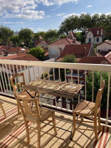 a deck with a table and chairs on a balcony at Charmant studio rénové 3 couchages Arcachon centre ville in Arcachon