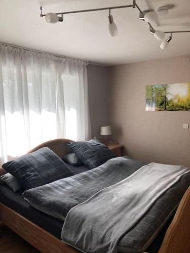 a bedroom with a large bed in front of a window at Ferienwohnung Eifel-Roedis in Blankenheim