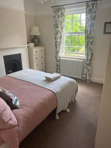 a bedroom with a bed and a window at Cosy cottage in town centre in Havant