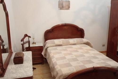 Schlafzimmer mit einem Bett mit einem Kopfteil aus Holz und einem Tisch in der Unterkunft HERVEME AGAETE in Agaete