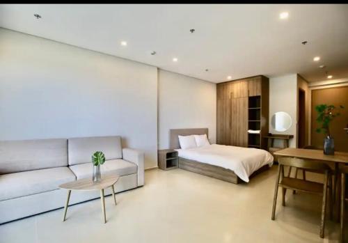 um quarto com uma cama, um sofá e uma mesa em Kem Beach hotel em Phu Quoc