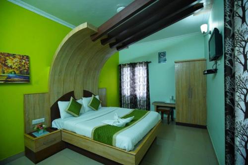 a bedroom with a large bed with green walls at Vpr residency ooty in Ooty