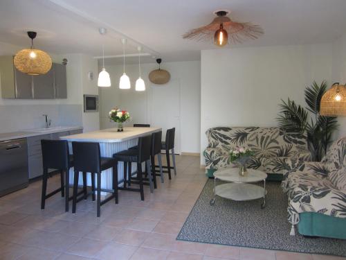 une cuisine et un salon avec une table et un canapé dans l'établissement Appartement Les Cigales Rez de Jardin à 10mn des plus belles plages, à Hyères