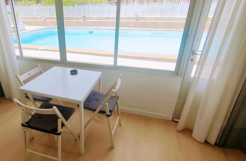 tavolo e due sedie e tavolo e piscina di APARTAMENTO BONITO 103 a Playa del Ingles