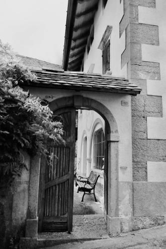a bench sitting in front of a building with a gate at Casa di Carla in Lauco