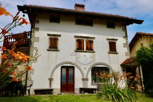 una vecchia casa con una porta rossa di Casa di Carla a Lauco