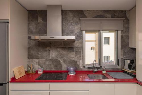 uma cozinha com um balcão vermelho e um lavatório em Casa Sarco em San Fernando