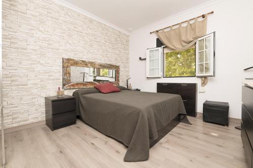 um quarto com uma cama e uma parede de tijolos em Casa Sarco em San Fernando