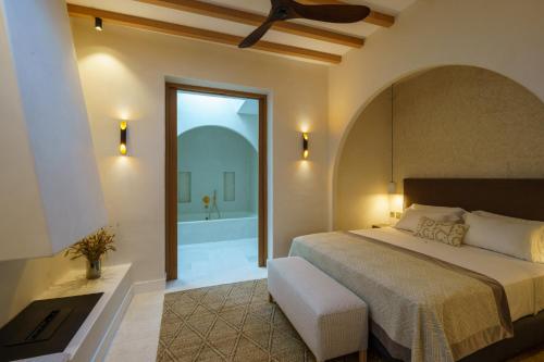 1 dormitorio con 1 cama grande y bañera en Cortijo Boutique Siete Calas, en Rodalquilar