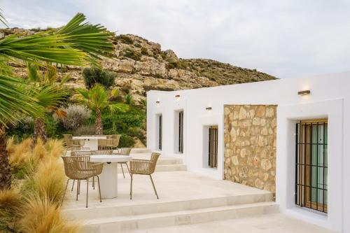 an outdoor patio with a table and chairs at Cortijo Boutique Siete Calas in Rodalquilar