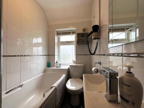 a bathroom with a tub and a toilet and a sink at Maria's House in East London in Dagenham