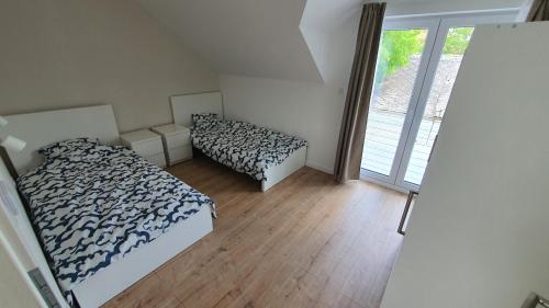 a bedroom with two beds and a large window at Velence Lakeside Pool House in Velence