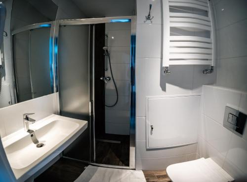 a bathroom with a shower and a sink and a toilet at Sanatorium Perla Baltyku in Kołobrzeg