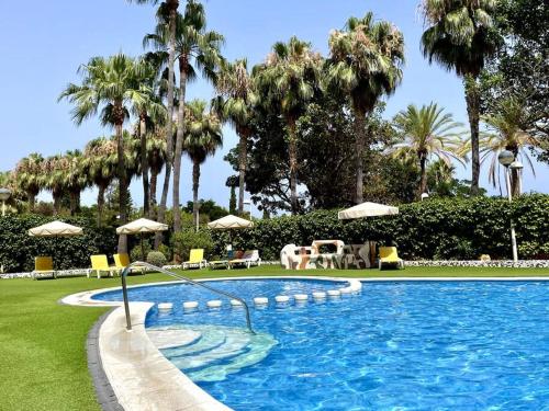 una piscina con sillas y sombrillas en un complejo en Primera línea de mar con terraza ático en Magic World - Marina Dor en Oropesa del Mar