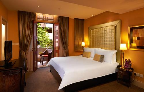 a bedroom with a large white bed and a balcony at Aurum Royal in Singapore