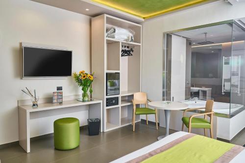 a room with a bed and a table and a tv at Hotel Miramare in Marina di Varcaturo