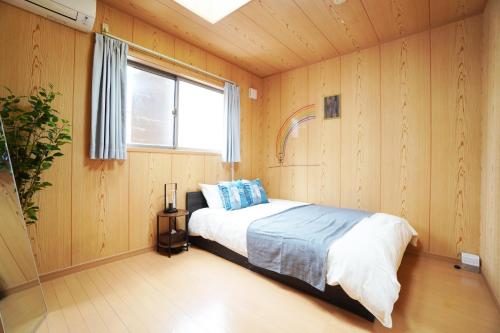 - une chambre avec un lit dans une pièce dotée d'une fenêtre dans l'établissement Miuranoyado, à Osaka