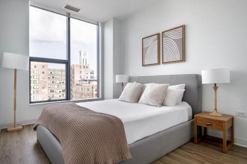 a white bedroom with a large bed and a window at West Loop 2br w theater gym nr restaurant row CHI-950 in Chicago