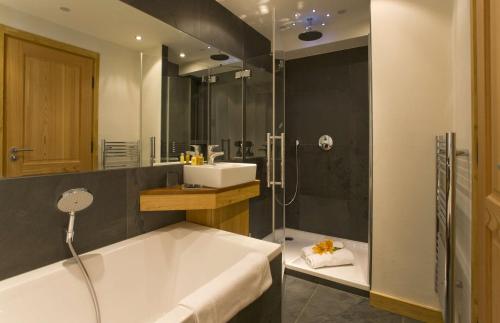 a bathroom with a tub and a sink and a shower at Chalet Cree - Haute Collection in Chamonix