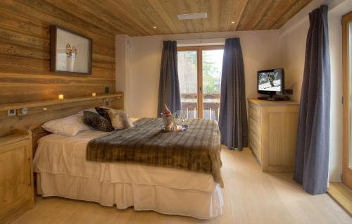 - une chambre avec un lit et une télévision dans l'établissement Chalet Cree - Haute Collection, à Chamonix-Mont-Blanc