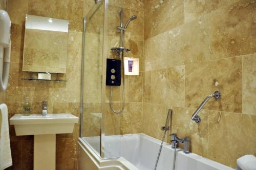 a bathroom with a shower and a tub and a sink at Bove Town House Apartments in Glastonbury