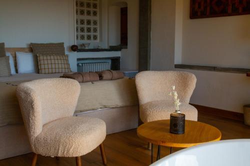 two chairs and a table in a living room at Santa Llúcia Rupit in Rupit