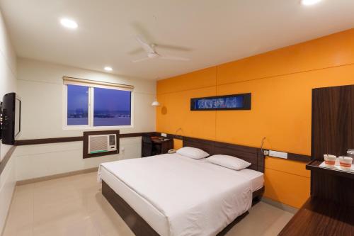 a bedroom with a bed and a tv in it at Ginger Jaipur in Jaipur