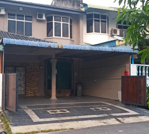 una casa con un garaje con toldo azul en Aaira Sophea Islamic Homestay en Batu Pahat