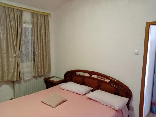 Schlafzimmer mit einem Bett mit rosa Bettwäsche und einem Fenster in der Unterkunft Casa di Vacanza in Porto Tolle