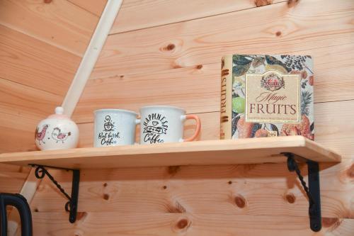 een plank met drie koffiekopjes en een boek bij Cottages Big bear in Žabljak