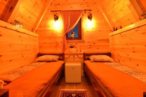 a bedroom with two beds in a log cabin at Cottages Big bear in Žabljak
