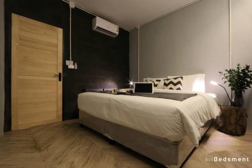 a bedroom with a bed with a laptop on it at Bedsment@Hayaek in Chiang Rai
