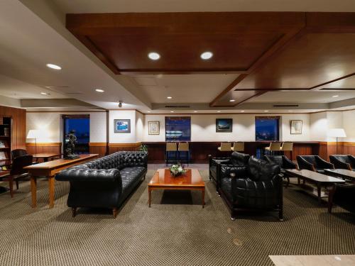 a waiting room with black leather chairs and tables at Premier Hotel -Tsubaki- Sapporo in Sapporo