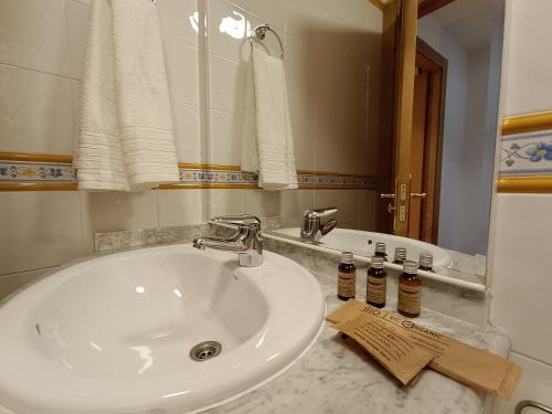 y baño con lavabo blanco y espejo. en Casa Guadalupe en Llanes