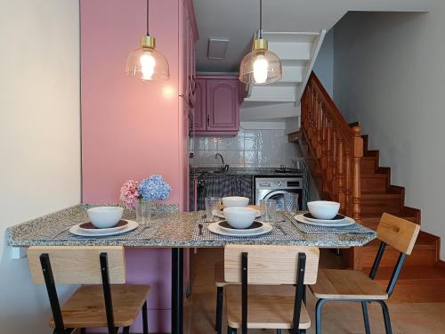 una cocina con una mesa con sillas y cuencos. en Casa Guadalupe en Llanes